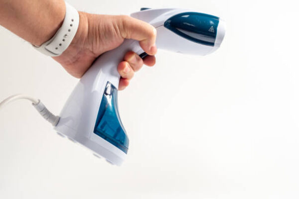 In hand Steamer for clothes on a white background. Portable iron. Iron for ironing clothes.